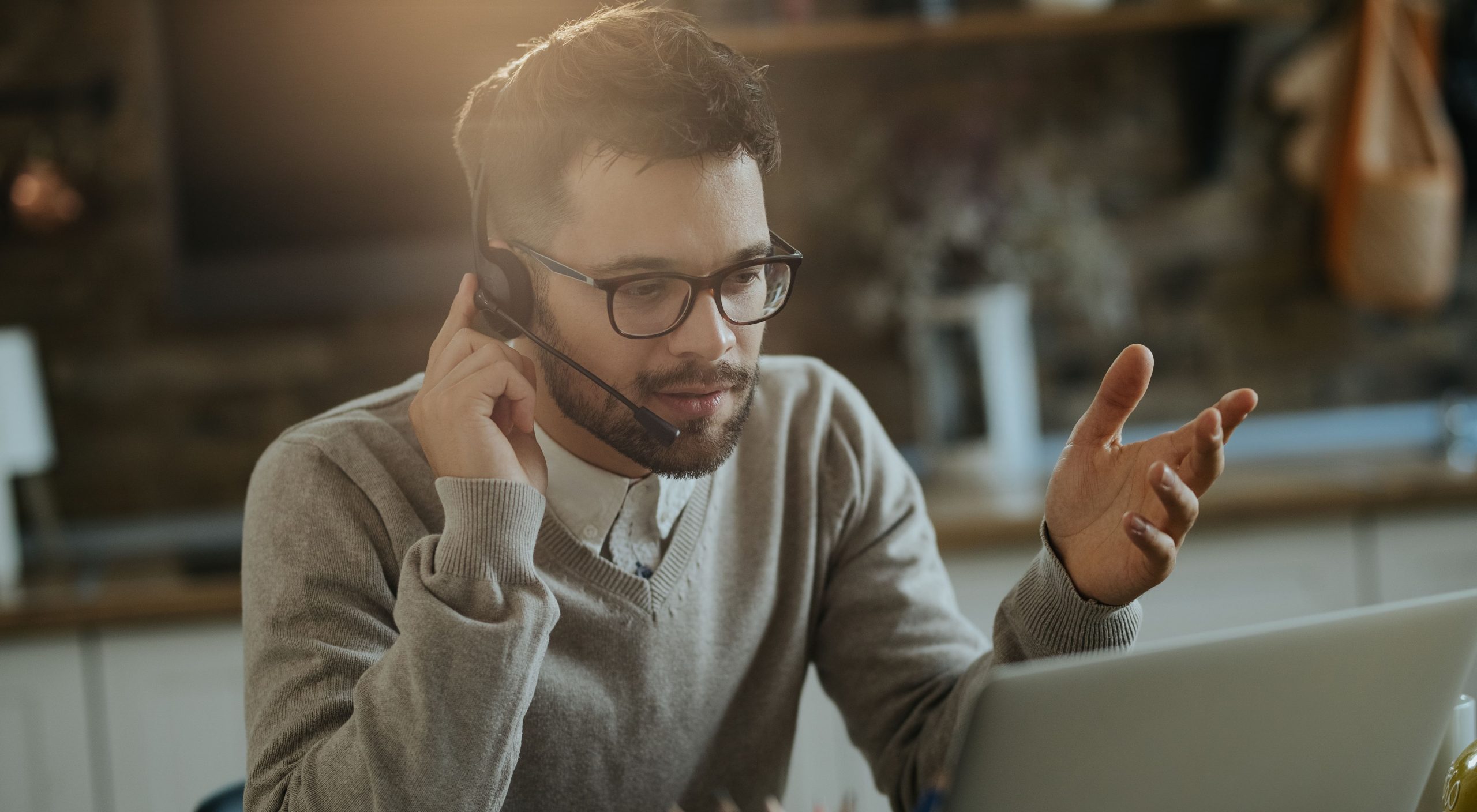 young entrepreneur having conference call computer while working home min scaled e1681348204269